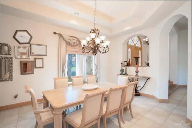 a dining room with wooden floor a chandelier a wooden table and chairs