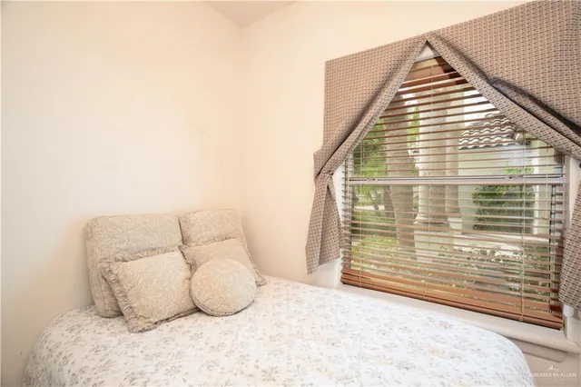 a view of a bedroom with a bed and a chair