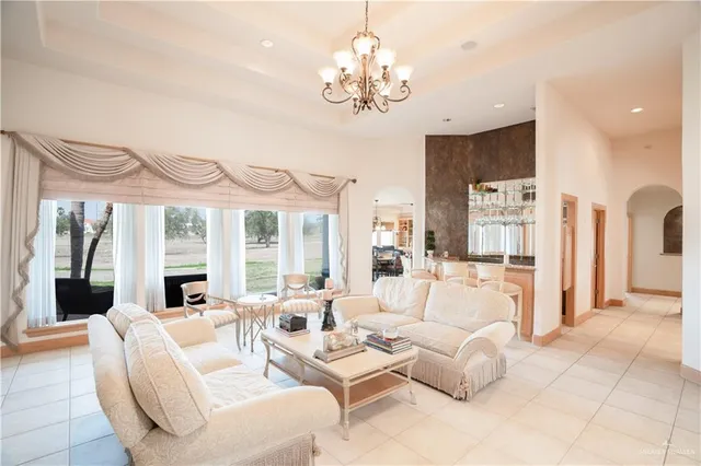 a living room with furniture a chandelier and a large window