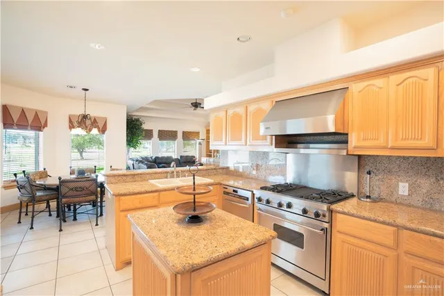 a kitchen with a stove a sink cabinets and wooden floor