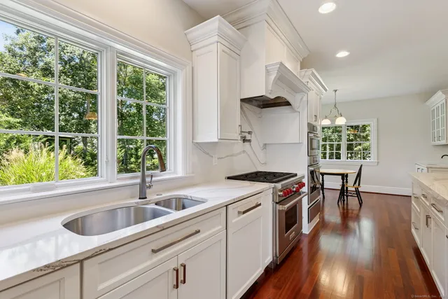 a kitchen with a stove a sink a center island and a window