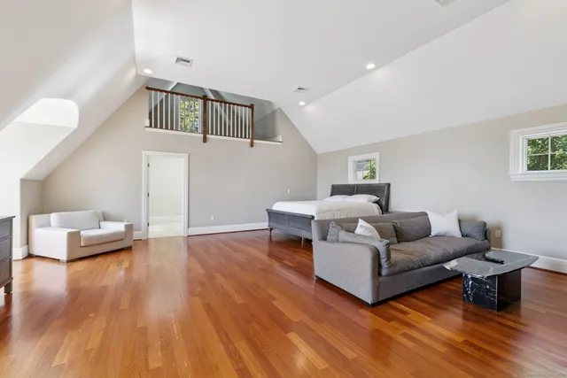 a spacious bedroom with a bed and a wooden floor