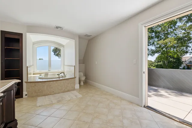 a view of a floor to ceiling window and tree in the background