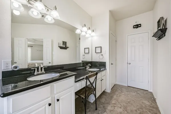 a bathroom with a sink vanity granite and a mirror