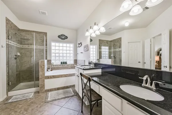 a spacious bathroom with a granite countertop sink a toilet a mirror and shower