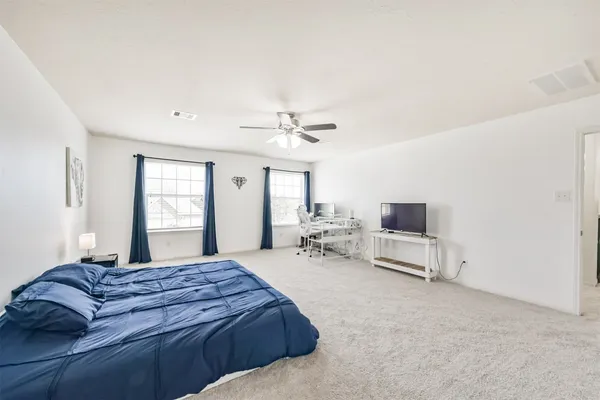 a spacious bedroom with a bed and a chandelier