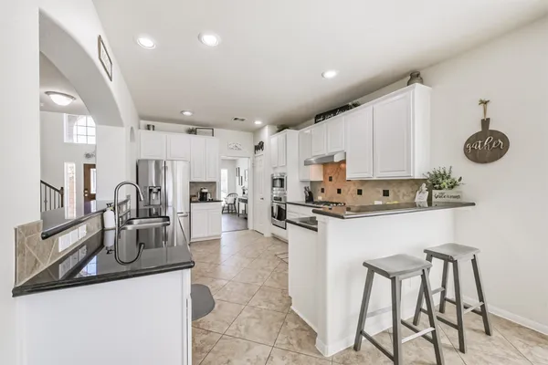 a kitchen with stainless steel appliances kitchen island granite countertop a sink and cabinets