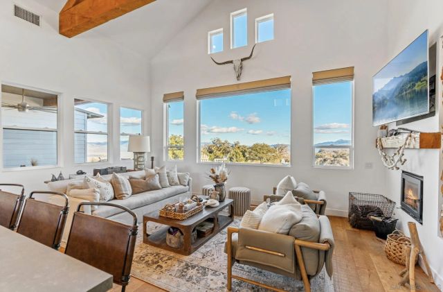 a living room with furniture a fireplace and a large window
