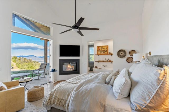 a spacious bedroom with a bed and a flat screen tv