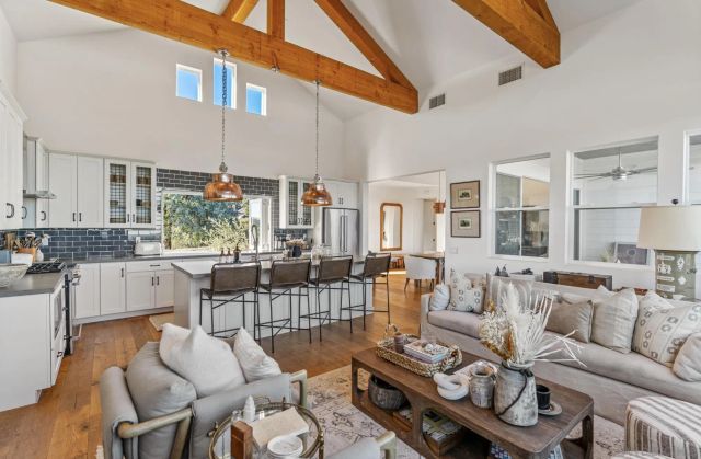 a very nice looking living room with a large window and kitchen view