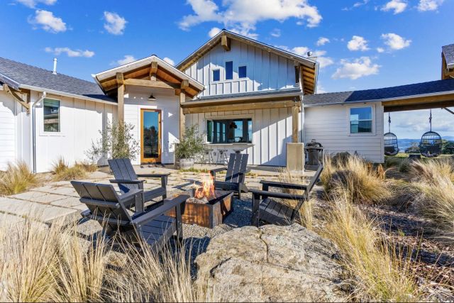 a view of a house with backyard and sitting area
