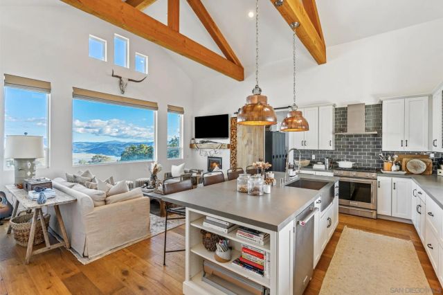 a kitchen with stainless steel appliances granite countertop a stove a refrigerator a oven a sink dishwasher and white cabinets with wooden floor