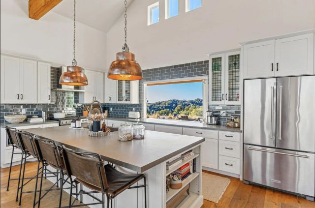 a kitchen with stainless steel appliances a sink a stove and a wooden floor