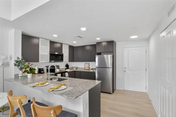 a kitchen with refrigerator and chairs