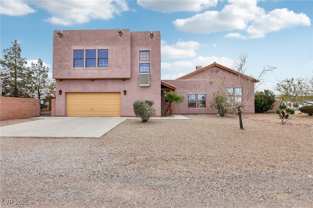 519 North Racetrack Road Henderson, NV 89015 - Photo 7 of 98 Southwest-style home with driveway, an attached garage, fence, and stucco siding