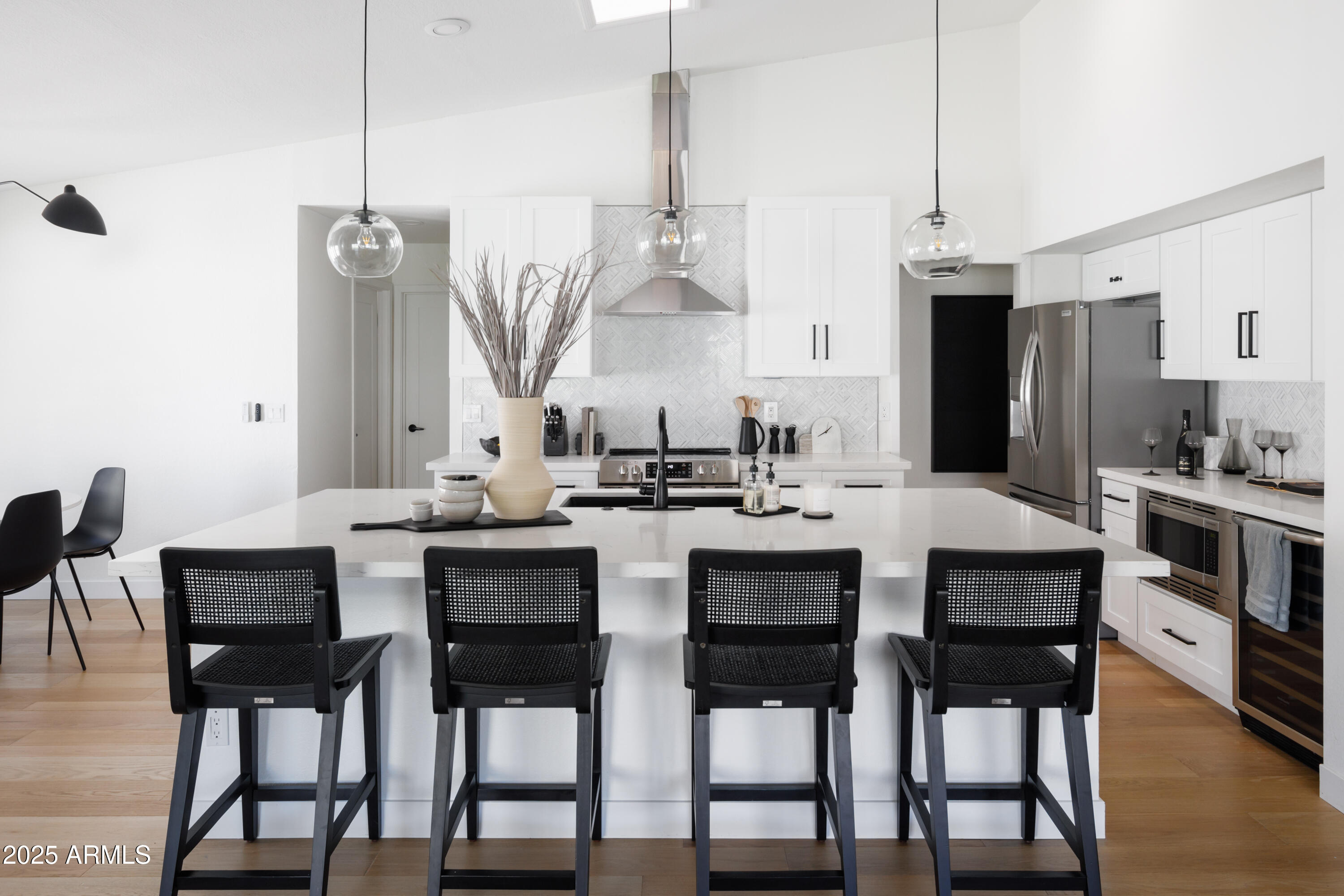 5502 East Grandview Road Scottsdale, AZ 85254 - Photo 12 of 42 a kitchen with a dining table chairs and white cabinets