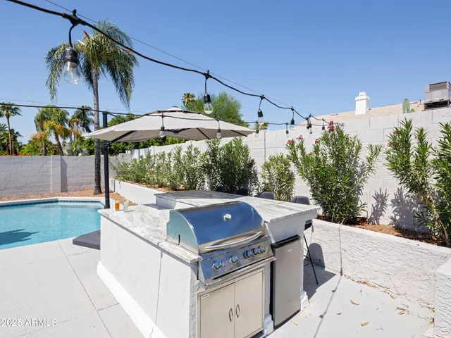 a view of a patio with a table and chairs under an umbrella