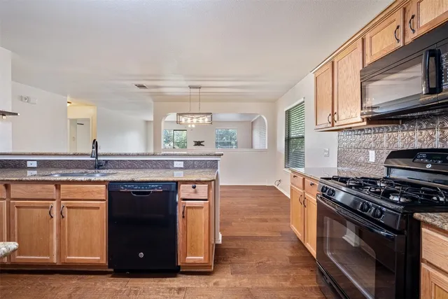 a kitchen with stainless steel appliances granite countertop a stove and a sink
