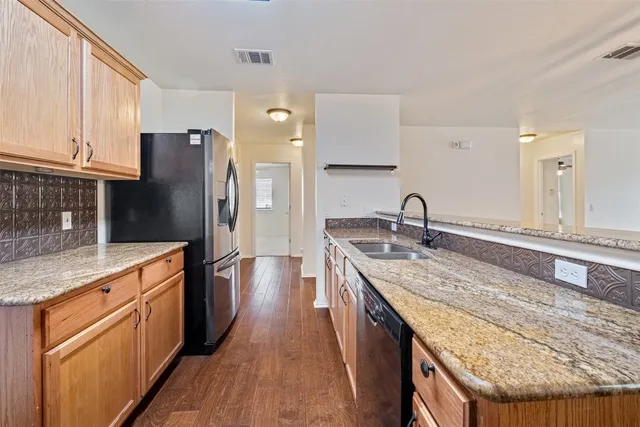 a kitchen with stainless steel appliances granite countertop a sink stove and refrigerator