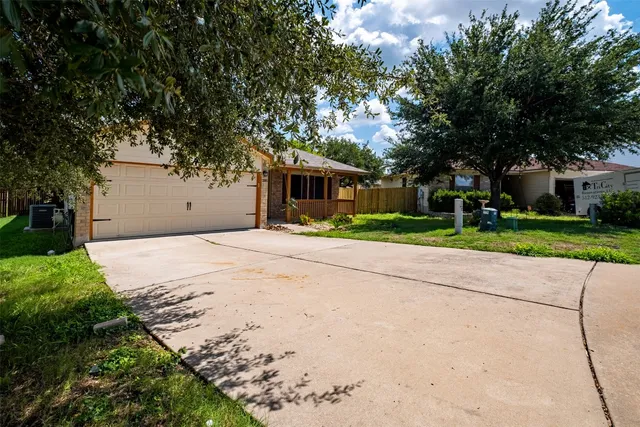 a front view of a house with a yard and trees