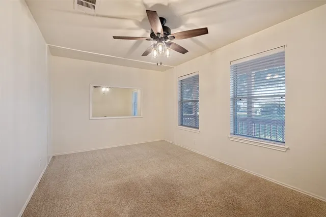 an empty room with fan and windows