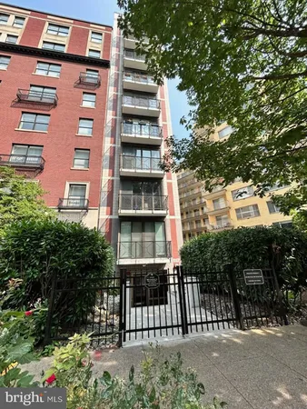 a front view of a multi story residential apartment building with a yard