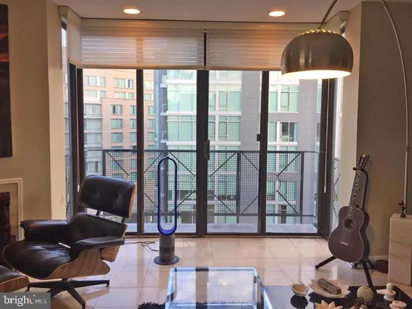 a living room with furniture and a floor to ceiling window