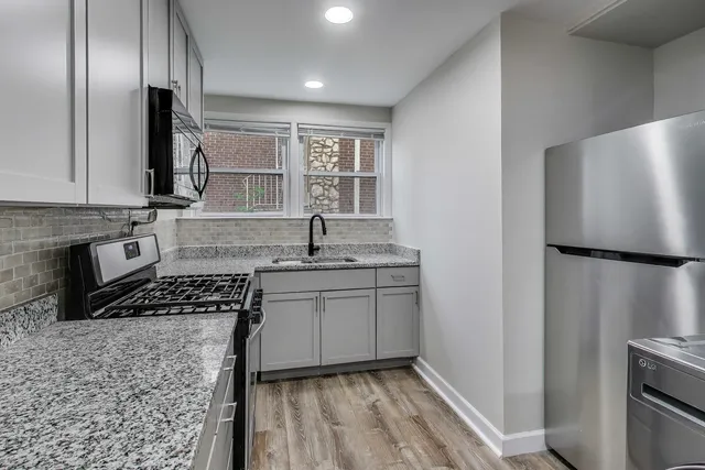 a kitchen with kitchen island granite countertop a stove and a refrigerator