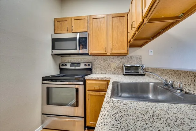 a kitchen with a stove a microwave and sink