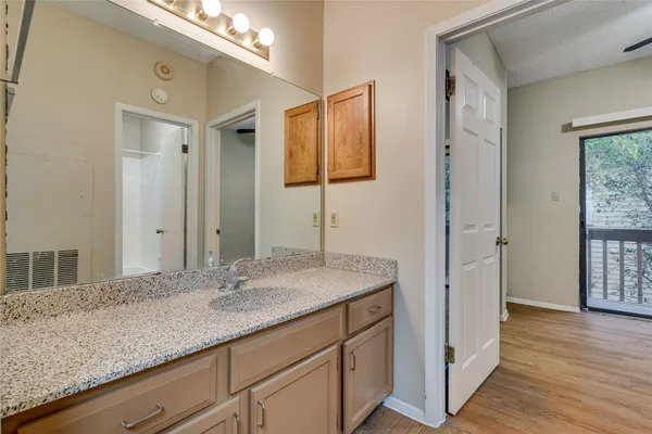 a bathroom with a granite countertop sink and a mirror