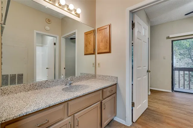 a bathroom with a granite countertop sink and a mirror