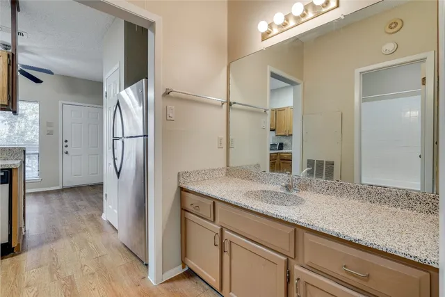 a bathroom with a granite countertop sink and a mirror