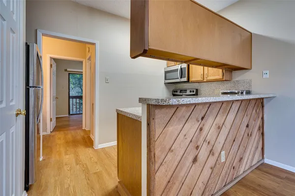 a kitchen with stainless steel appliances granite countertop wooden cabinets and a stove top oven