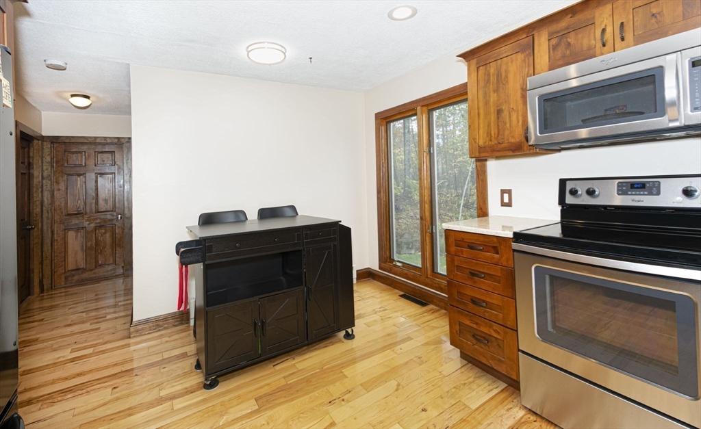 17 West Shore Drive Ashburnham, MA 01430 - Photo 11 of 42 a kitchen with stainless steel appliances a stove a microwave and a hard wood floor