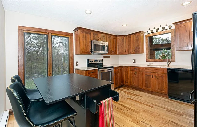 a kitchen with a table chairs microwave and window