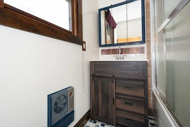 a bathroom with a sink a mirror and a window