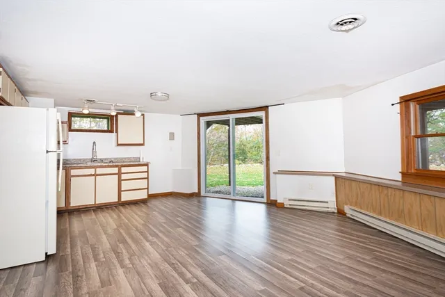 a kitchen with stainless steel appliances wooden floors and white walls