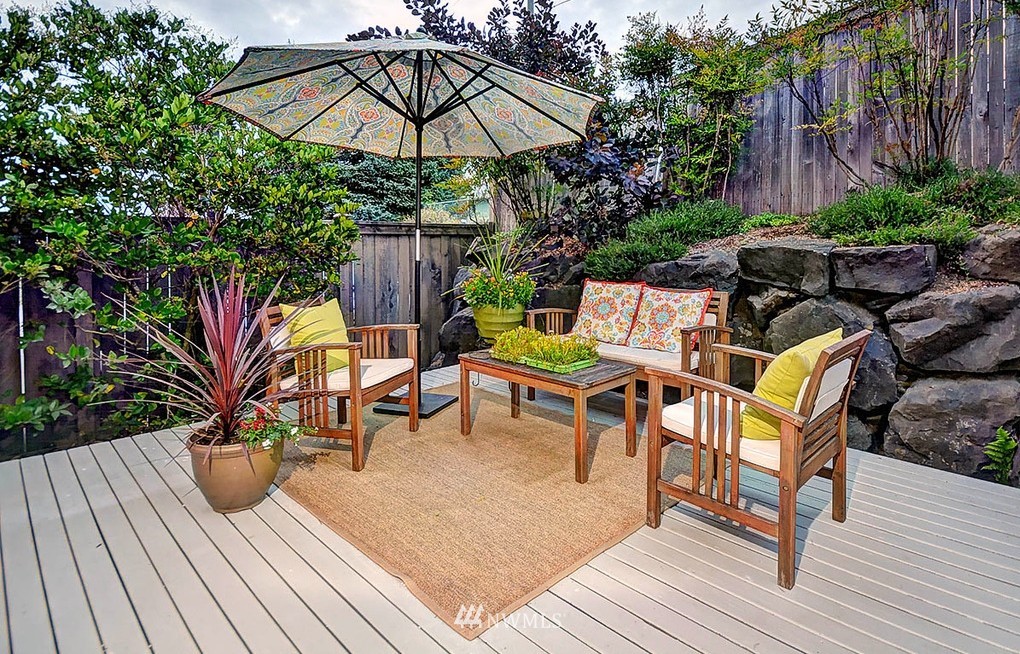 906 North 27th Place Renton, WA 98056 - Photo 16 of 25 a view of a roof deck with table and chairs under an umbrella with wooden floor