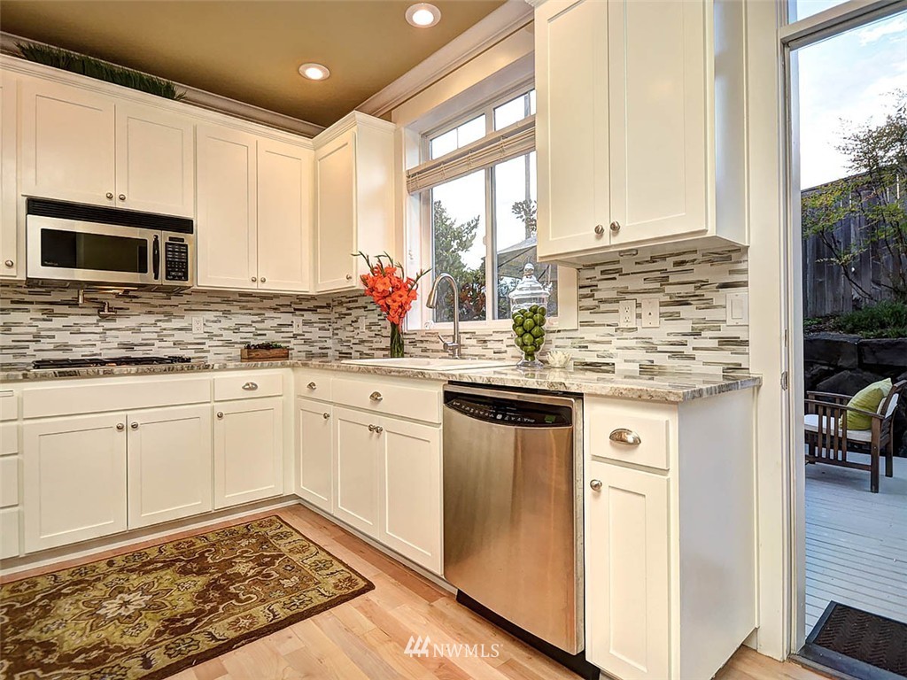 906 North 27th Place Renton, WA 98056 - Photo 18 of 25 a kitchen with stainless steel appliances kitchen island granite countertop a sink stove and cabinets