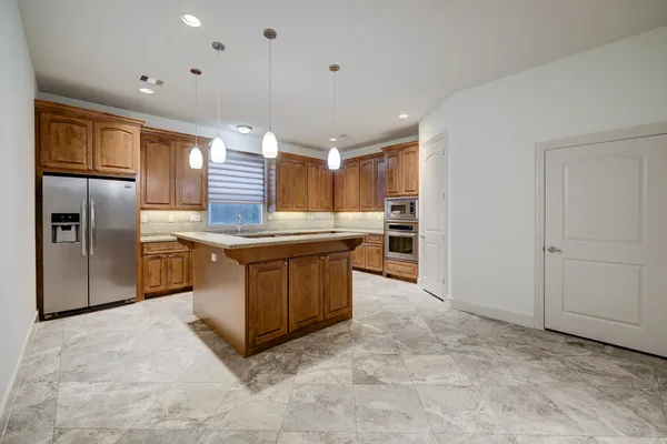 a kitchen with stainless steel appliances granite countertop a sink a stove a refrigerator and cabinets