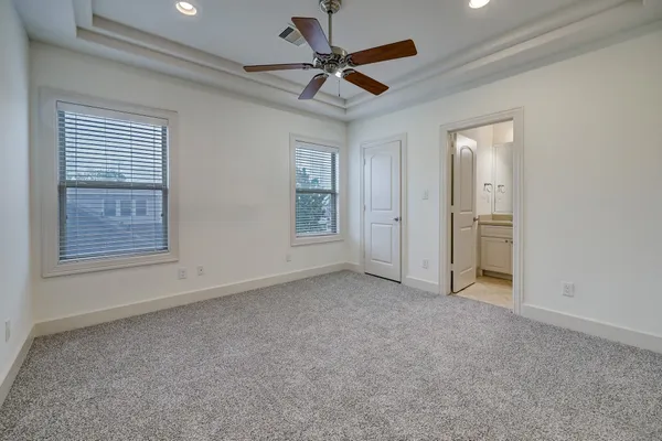 an empty room that has a window and a ceiling fan