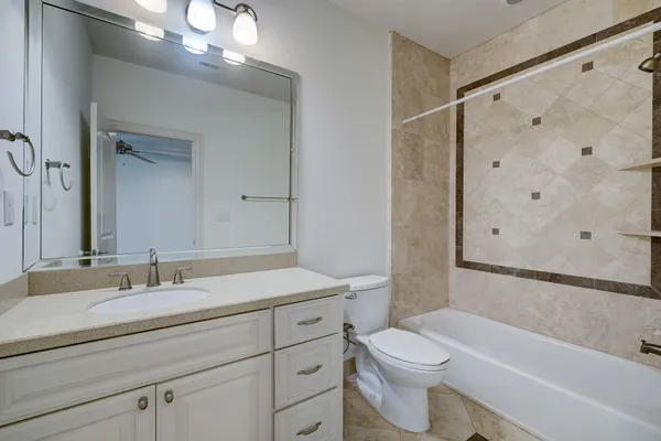 a bathroom with a granite countertop sink a toilet and shower