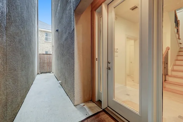 a view of a hallway with wooden floor and a bathroom
