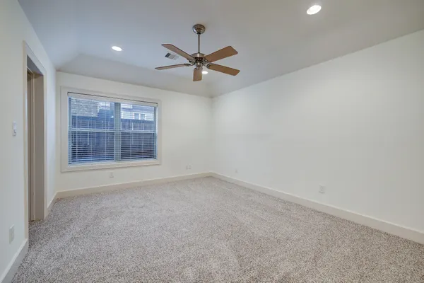 an empty room with windows and fan