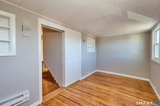 an empty room with wooden floor and entrance