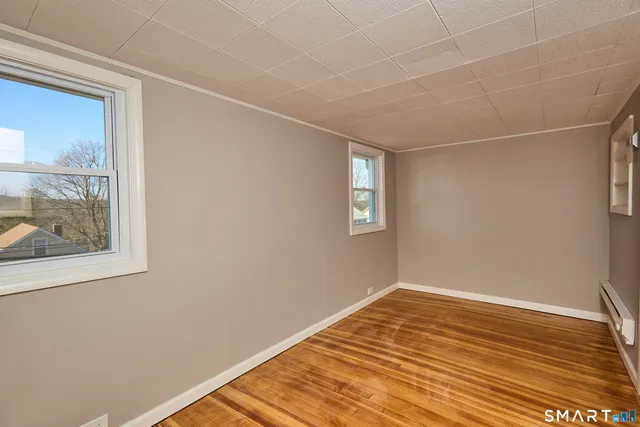 a view of a room with wooden floor and windows
