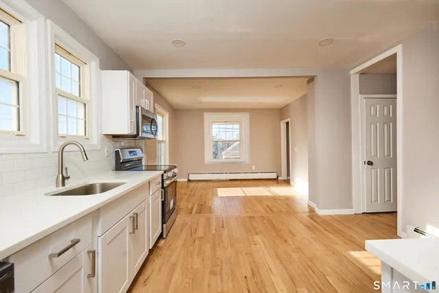 a view of a kitchen sink a counter space and windows