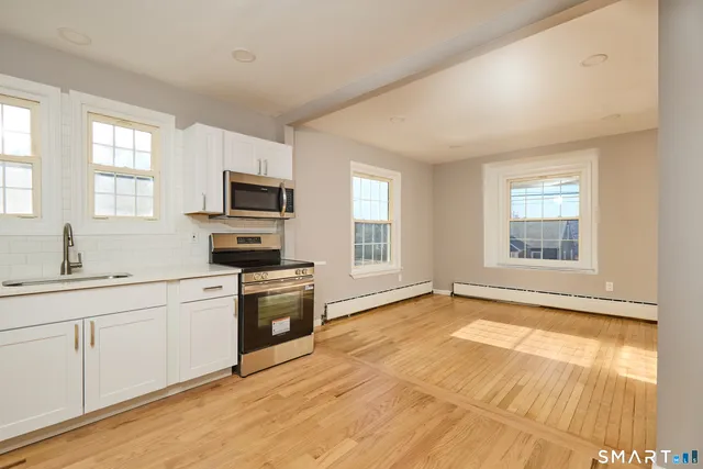 a kitchen with granite countertop a stove a sink and a microwave