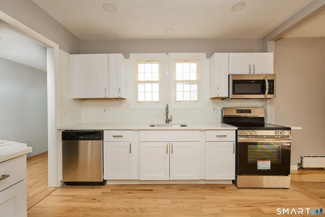 a kitchen with stainless steel appliances granite countertop a stove a sink and a microwave