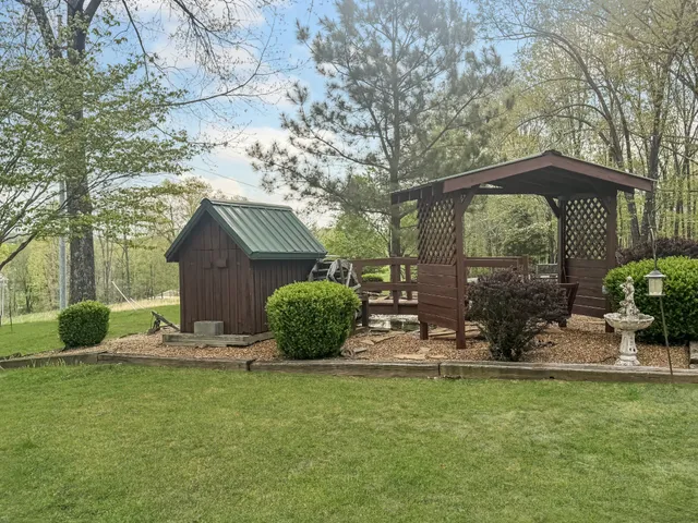 a view of a house with backyard and sitting area